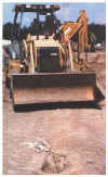 A child's burial, the remains removed, lies in
                     path of earth moving equipment